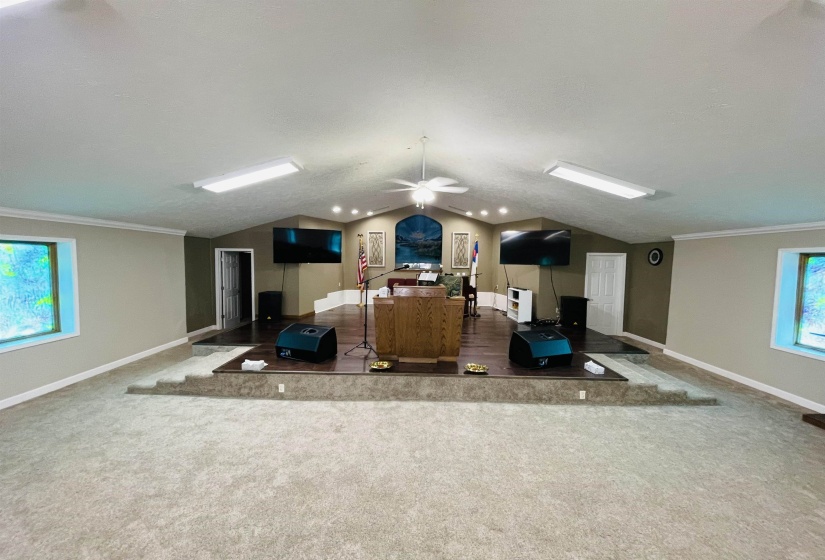 Carpeted bedroom featuring a textured ceiling, crown molding, and lofted ceiling