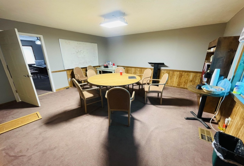 Dining room with carpet, wooden walls, and a wood stove