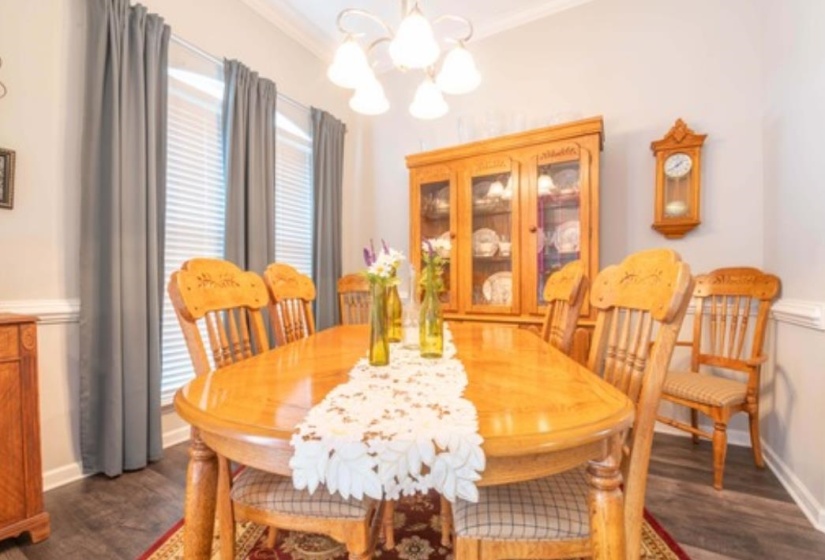 Dining room featuring a notable chandelier, dark hardwood / wood-style floors, and crown molding