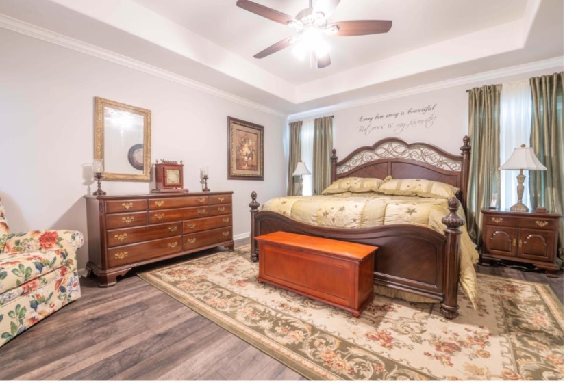 Bedroom with a tray ceiling, ceiling fan, hardwood / wood-style floors, and crown molding