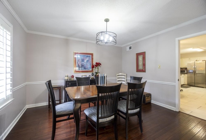 Dining room with Crown molding, a cool chandelier and Beautiful Hardwood Floors