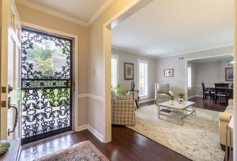 Foyer entrance with dark hardwood / wood-style floors and crown molding