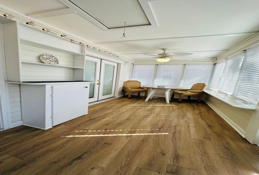 Unfurnished sunroom featuring a ceiling fan