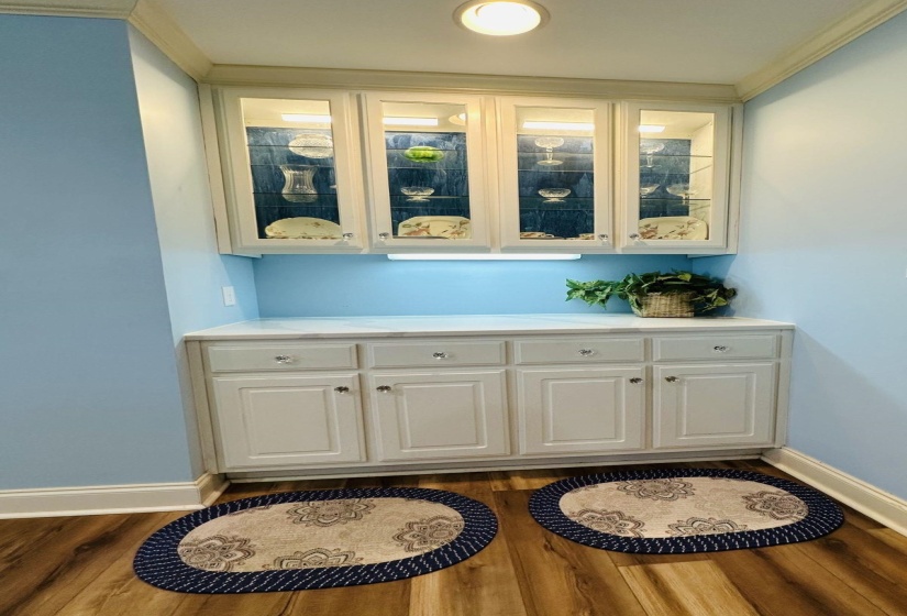 Bar with ornamental molding, dark wood-style flooring, and baseboards