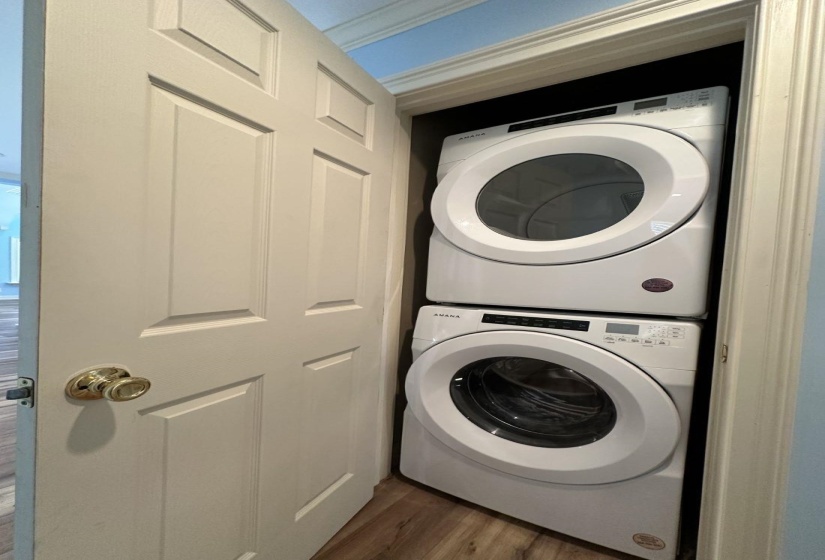 Laundry area with laundry area, dark wood finished floors, and stacked washer / drying machine
