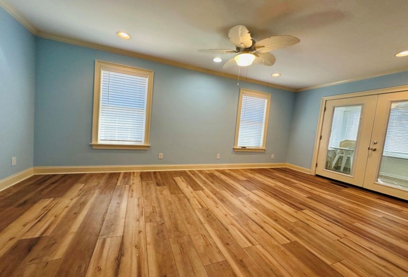 Spare room featuring french doors, ornamental molding, light wood-type flooring, and baseboards