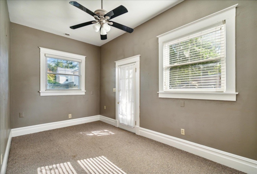 Empty room with ceiling fan, carpet flooring, and plenty of natural light