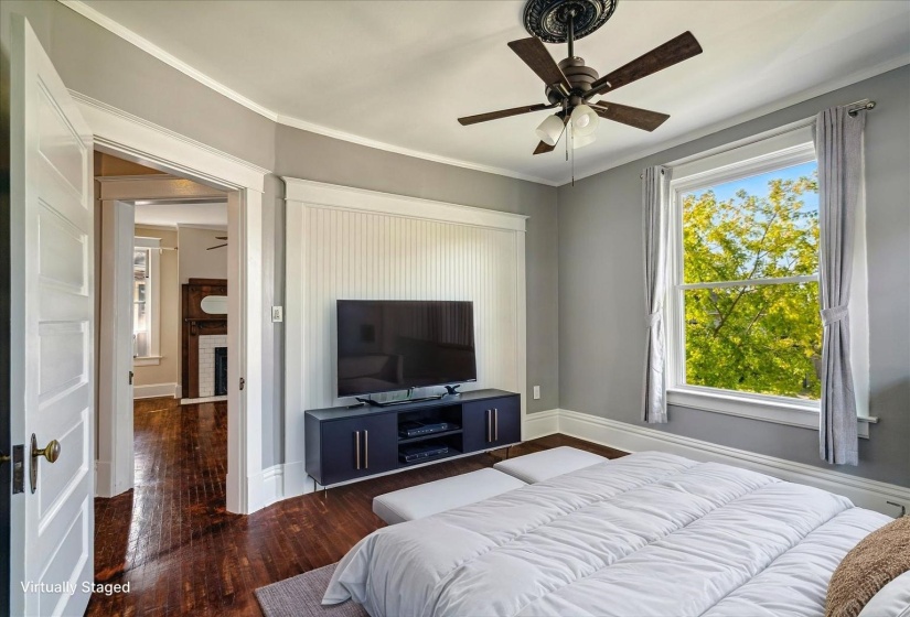 Bedroom with wood finished floors and multiple windows
