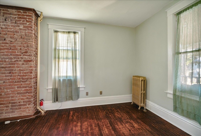 Spare room with dark wood-type flooring and radiator