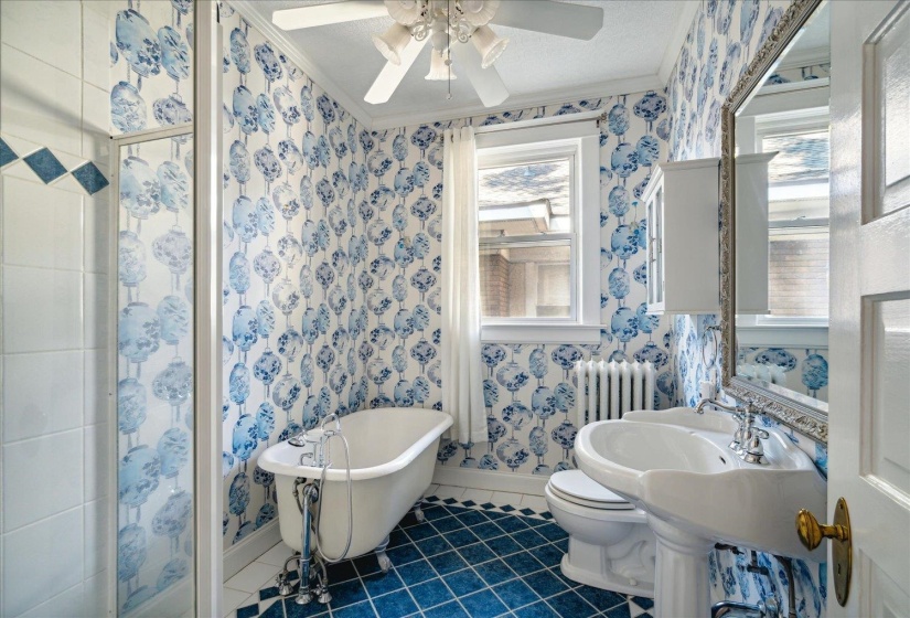 Bathroom featuring ornamental molding, toilet, a tub, and tile patterned flooring