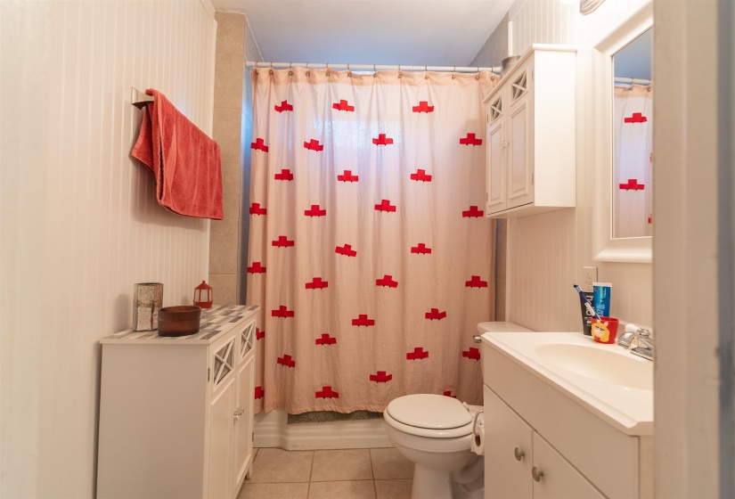 Bathroom with shower, tile patterned floors, vanity, and toilet