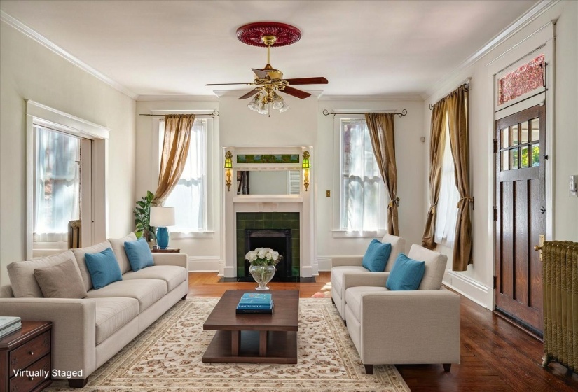 Living area featuring ceiling fan, plenty of natural light, wood finished floors, and ornamental molding