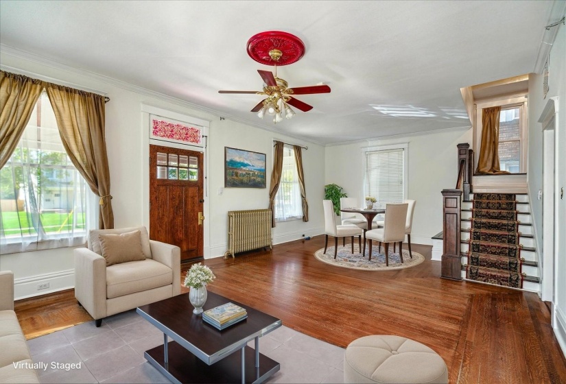 Living area with radiator, stairs, a ceiling fan, crown molding, and tile patterned flooring