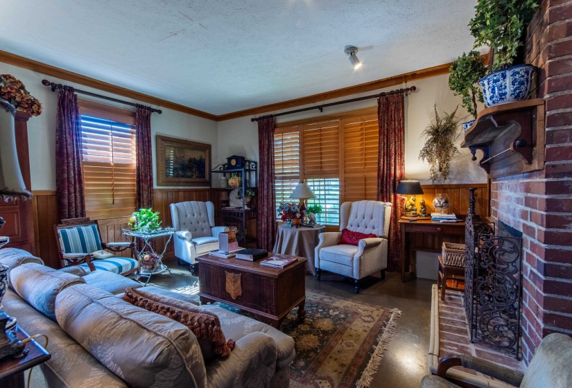 Living room featuring a textured ceiling, a healthy amount of sunlight, crown molding, and a brick fireplace