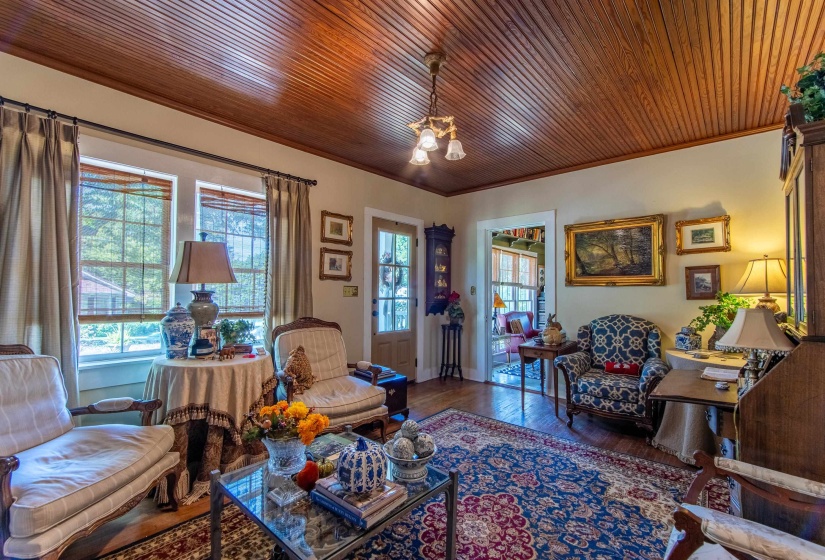 Living room featuring hardwood / wood-style flooring, wood ceiling, and crown molding