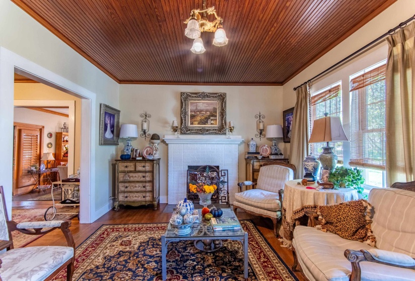 Living room with wooden ceiling, crown molding, a fireplace, and hardwood / wood-style floors