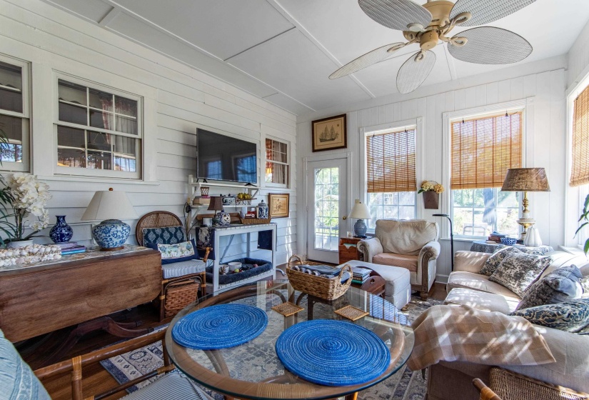 Living room with wood walls, ceiling fan, and hardwood / wood-style flooring