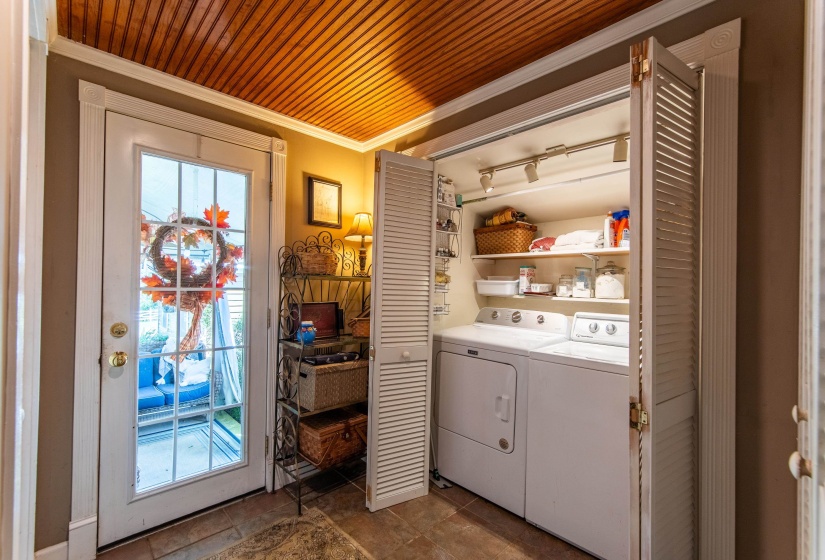 Laundry room featuring washing machine and clothes dryer, wooden ceiling, and ornamental molding