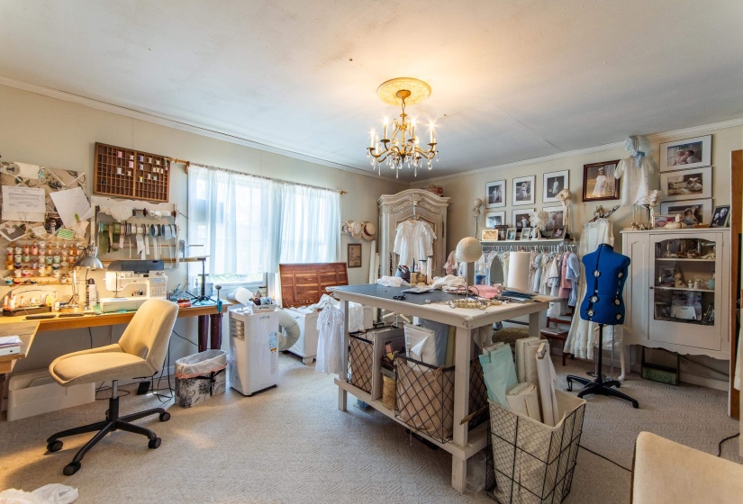 Office area featuring light carpet, a notable chandelier, and crown molding