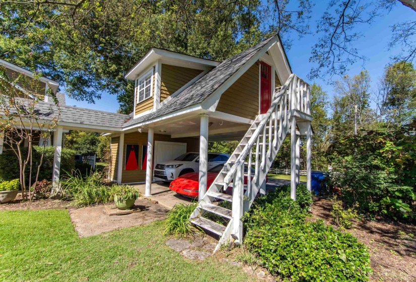 Back of property featuring a lawn and a carport