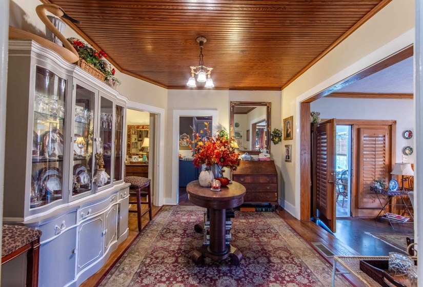 Entrance foyer with wood ceiling, a chandelier, dark wood-type flooring, and crown molding