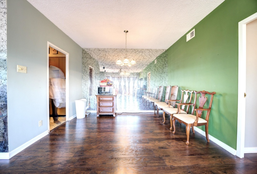 Dining area featuring a notable chandelier, a textured ceiling, and hardwood / wood-style flooring