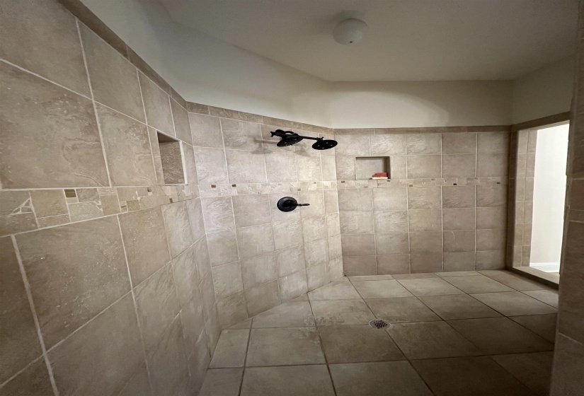 Bathroom with tile patterned floors, tile walls, and tiled shower