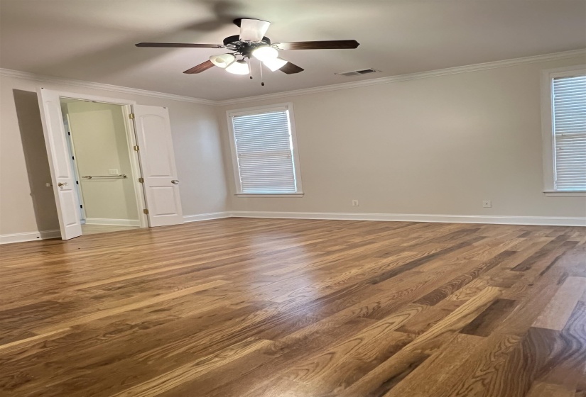 Unfurnished room with ceiling fan, wood-type flooring, and ornamental molding
