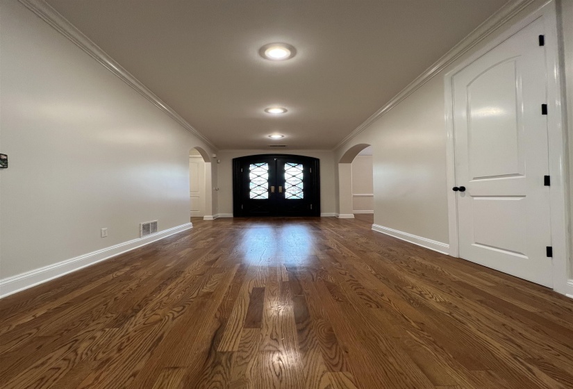 Foyer featuring french doors, dark wood-type flooring, and ornamental molding