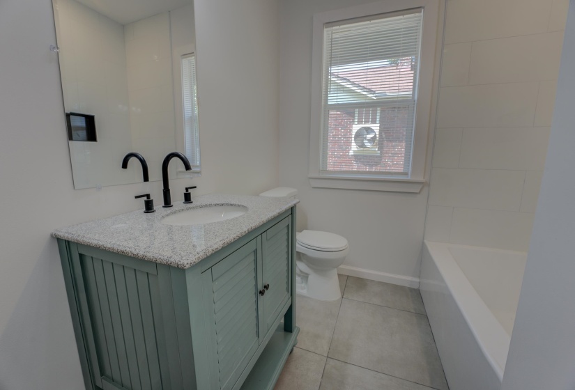 Bathroom featuring toilet, vanity, and tile patterned flooring