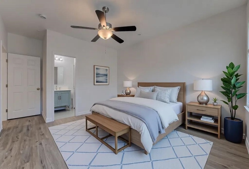 Bedroom with ceiling fan, connected bathroom, and light wood-type flooring