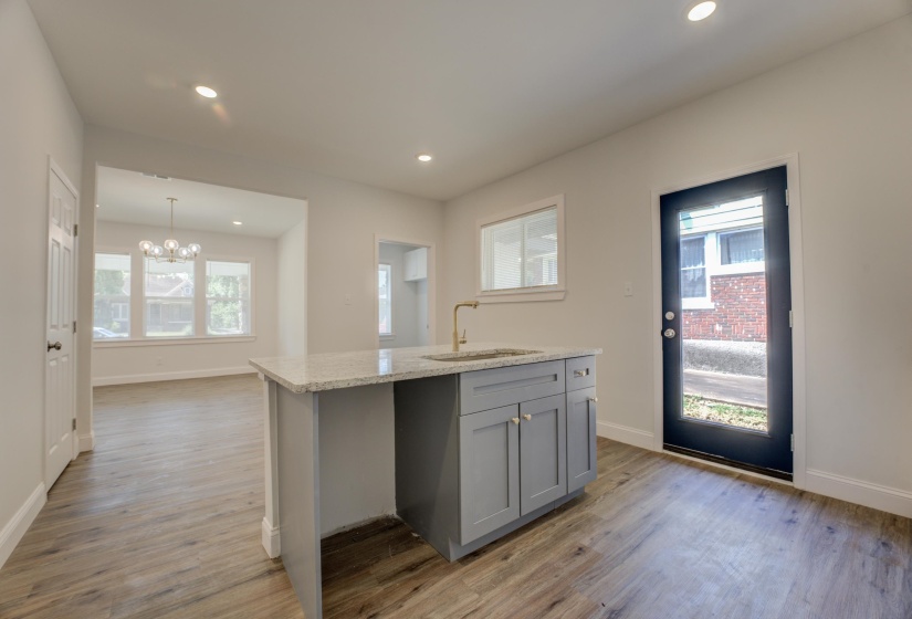 Kitchen featuring light hardwood / wood-style flooring, a center island with sink, and gray cabinets