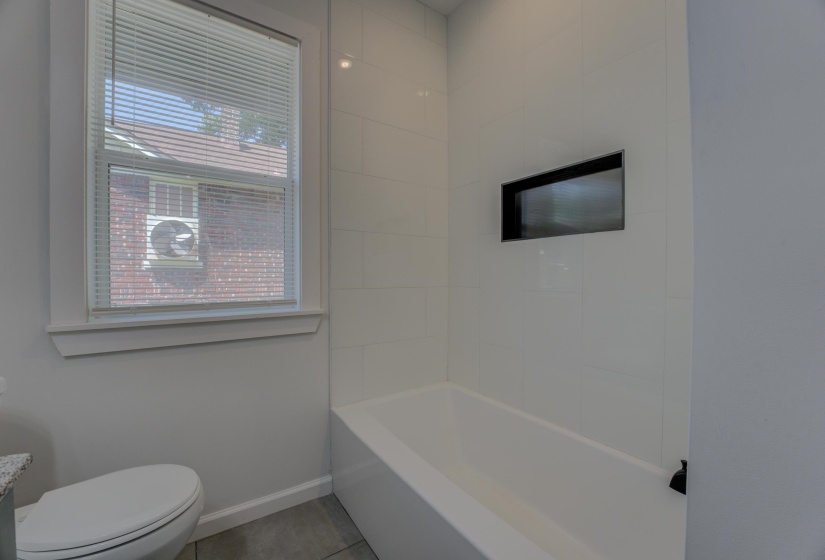 Bathroom featuring plenty of natural light, tile patterned flooring, and toilet