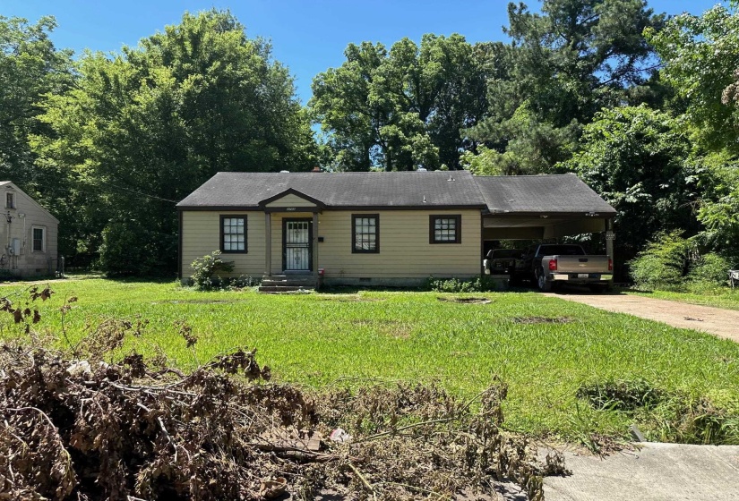 Single story home with a front lawn and a carport