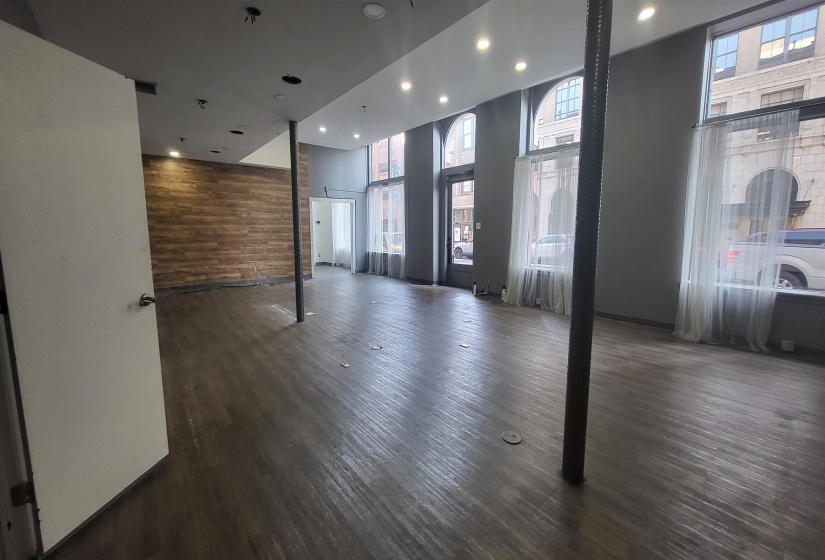 Spare room with dark wood-type flooring, wood walls, and a high ceiling