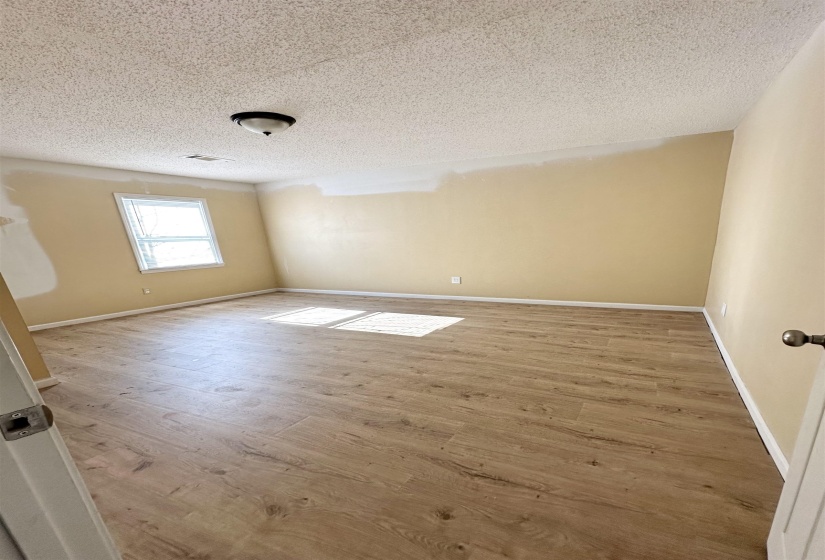 Empty room featuring hardwood / wood-style floors and a textured ceiling