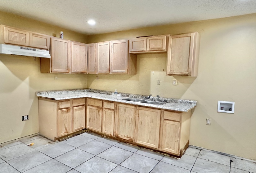 Kitchen featuring light brown cabinetry, light tile patterned floors, and sink
