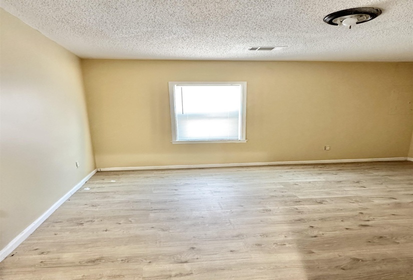 Spare room with light hardwood / wood-style floors and a textured ceiling
