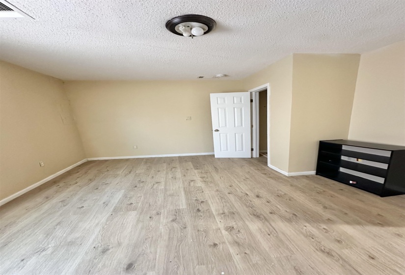 Interior space with light wood-type flooring and a textured ceiling