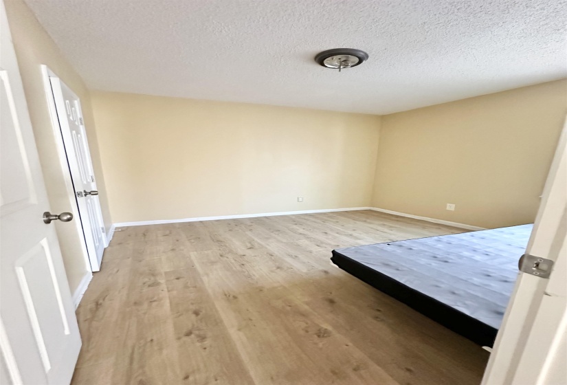 Unfurnished bedroom featuring a textured ceiling and light hardwood / wood-style flooring