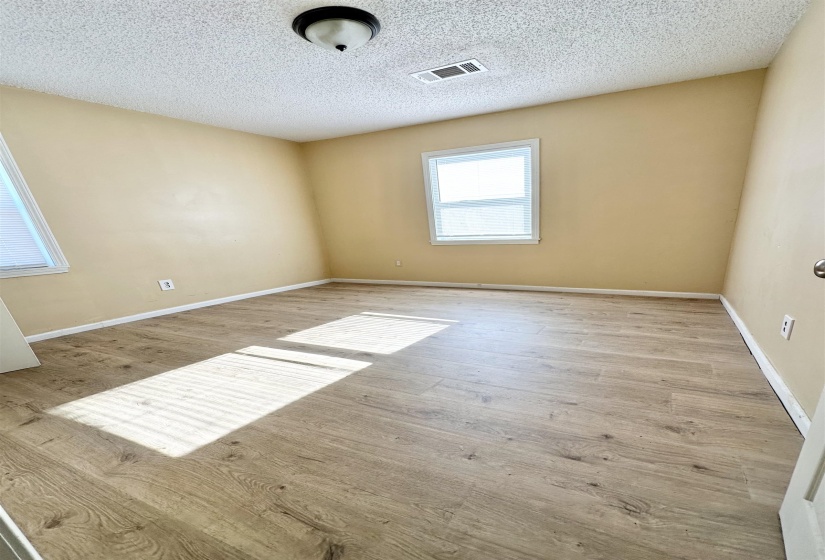 Spare room with a textured ceiling and light wood-type flooring