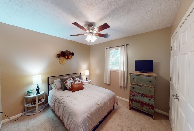Carpeted bedroom featuring a textured ceiling, a closet, and ceiling fan