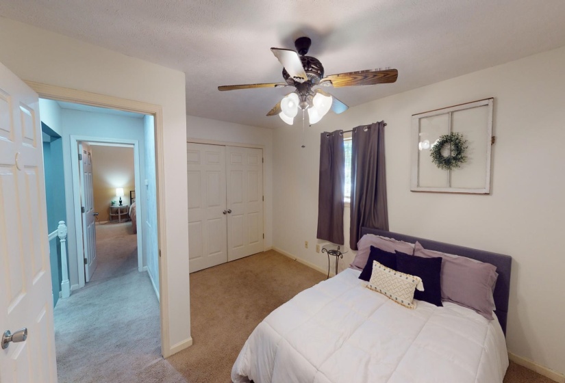Bedroom featuring a closet, ceiling fan, and light colored carpet