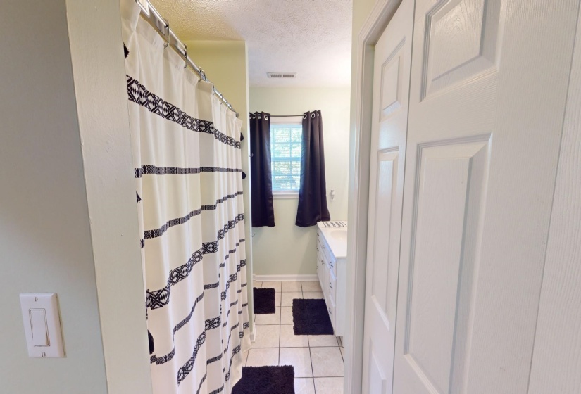 Bathroom with vanity, tile patterned floors, and a textured ceiling