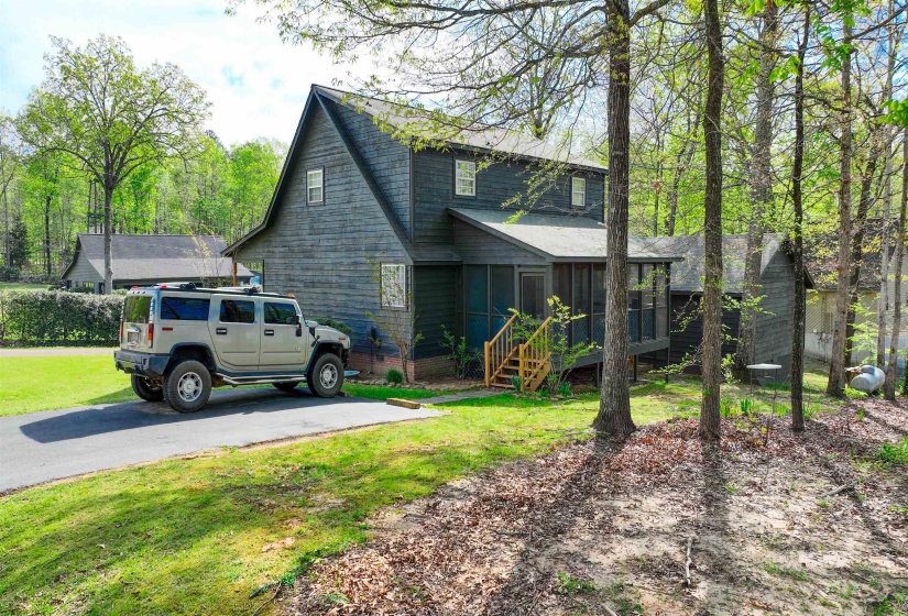 View of front facade featuring a sunroom, roof with shingles, and a front yard
