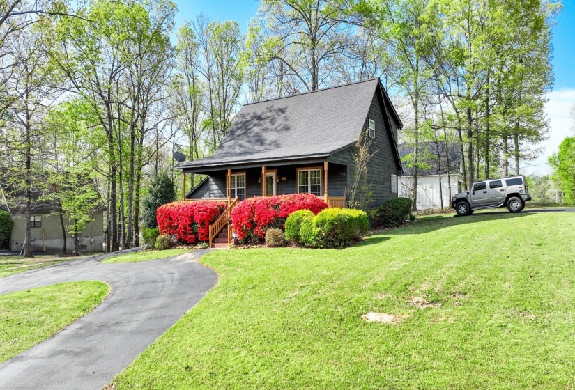 View of front facade featuring a front lawn, driveway, and a porch