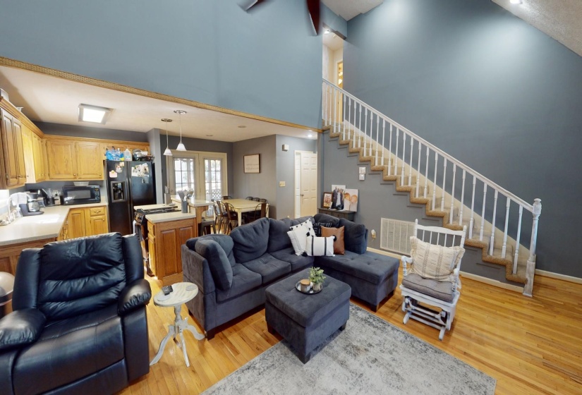 Living room with a towering ceiling and light wood-type flooring