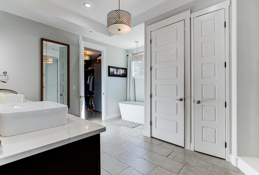 Bathroom featuring vanity, shower with separate bathtub, and tile patterned flooring