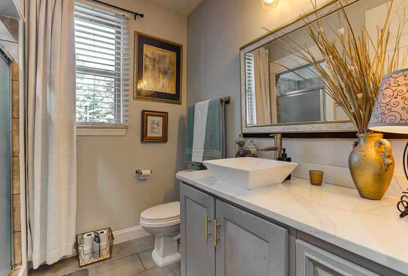 Bathroom with vanity, tile patterned flooring, toilet, and walk in shower
