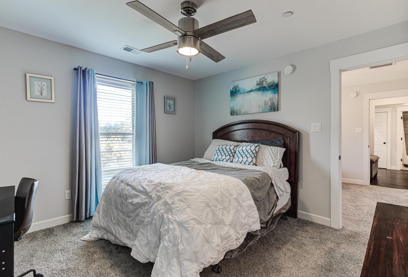 Carpeted bedroom featuring ceiling fan